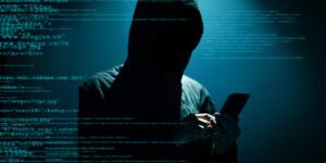 Hacker Hacker using phone at dark